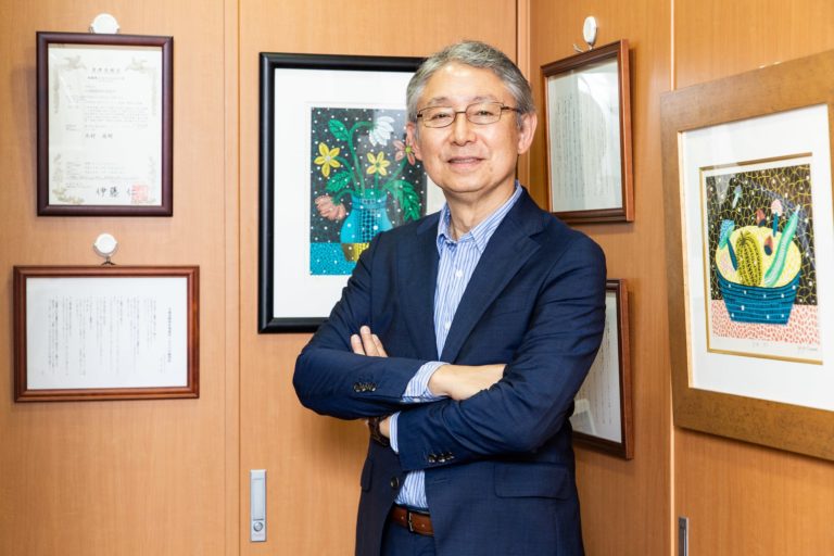 Takaaki Kimura, Managing Partner of Tokyo-based IP law firm, Kimura & Partners. Standing by framed certificates and artworks.